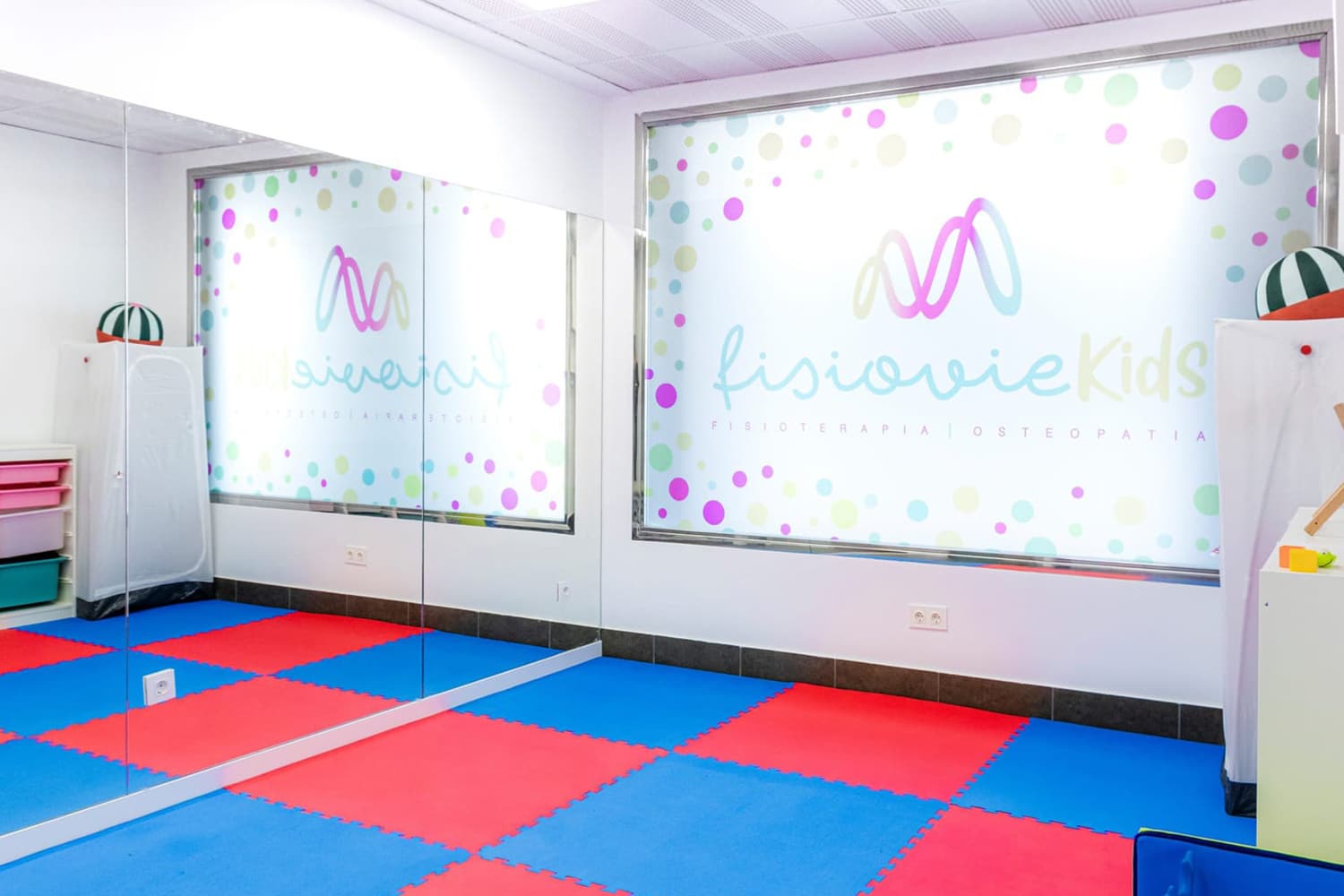 Sala de Fisiovie Kids con suelo de color azul y rojo