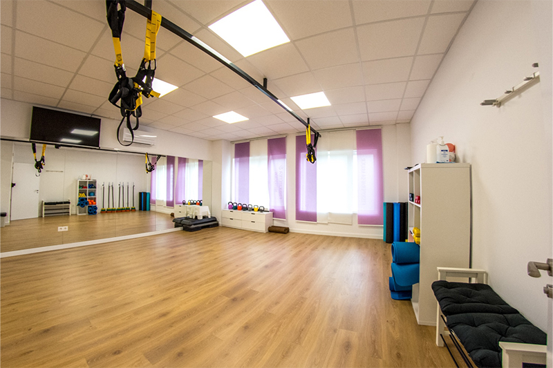 Sala de Fisioterapia Fisiovie Mujer con tarima flotante y cortinas moradas